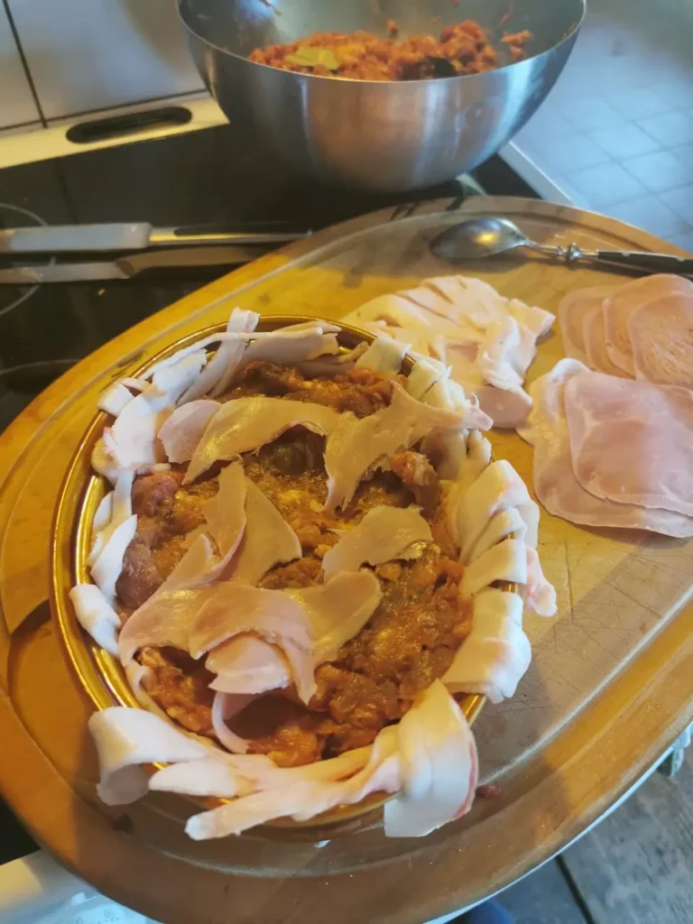 Fleischterrine in einer Form schichten