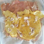 Rotolo mit Omelette und Schinken belegt.