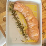 Rotolo zusammengerollt mit einem Rosmarin-Zweig in einer Pfanne mit Olivenöl