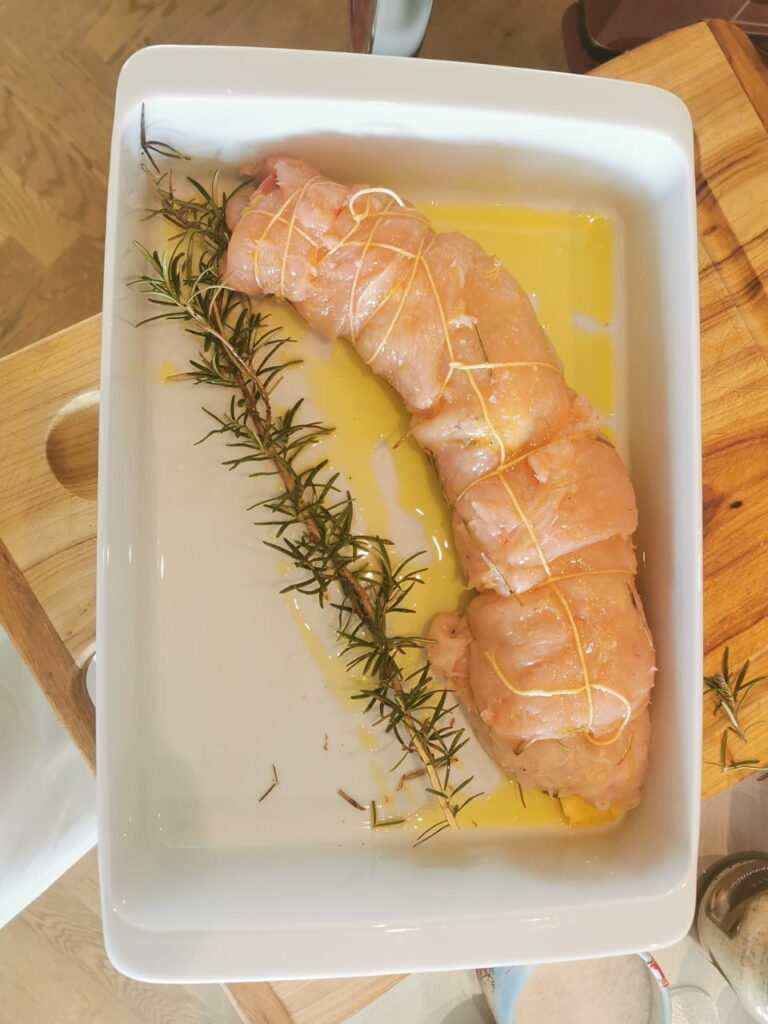 Rotolo zusammengerollt mit einem Rosmarin-Zweig in einer Pfanne mit Olivenöl