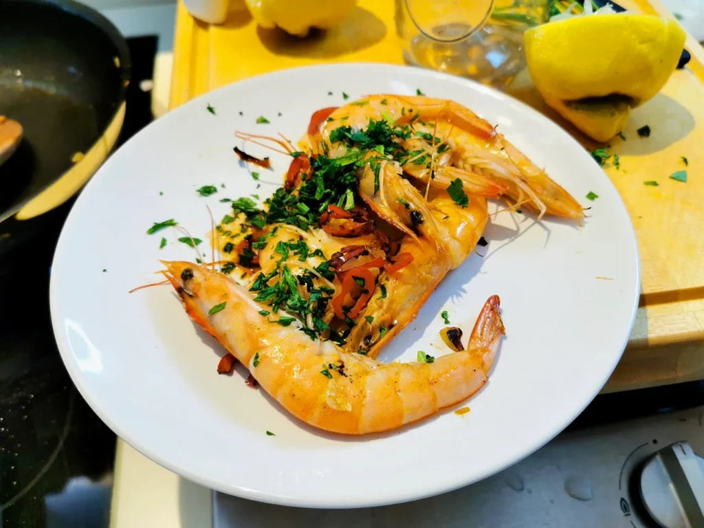 Fertige scharfe Shrimps mit Koriander, Limette und Chili auf einem Teller