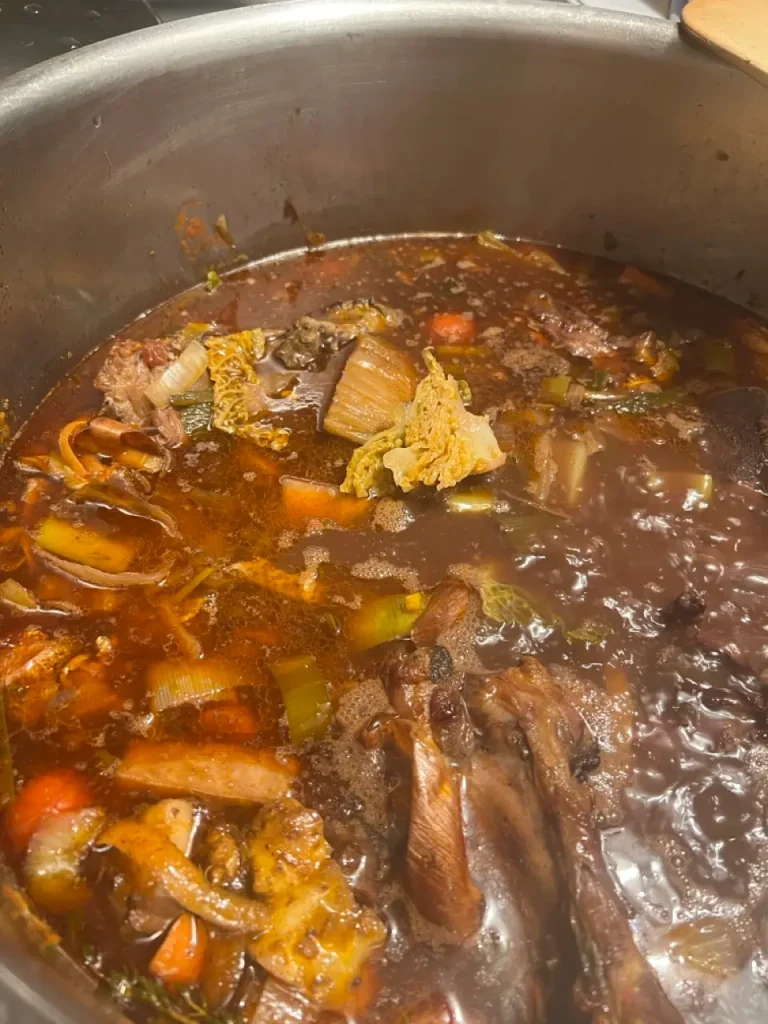Dunkle Demi-Glace köchelt in einem Topf auf dem Herd