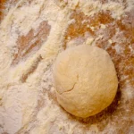 Zur Kugel geformter Pastateig ruht vor dem Ausrollen
