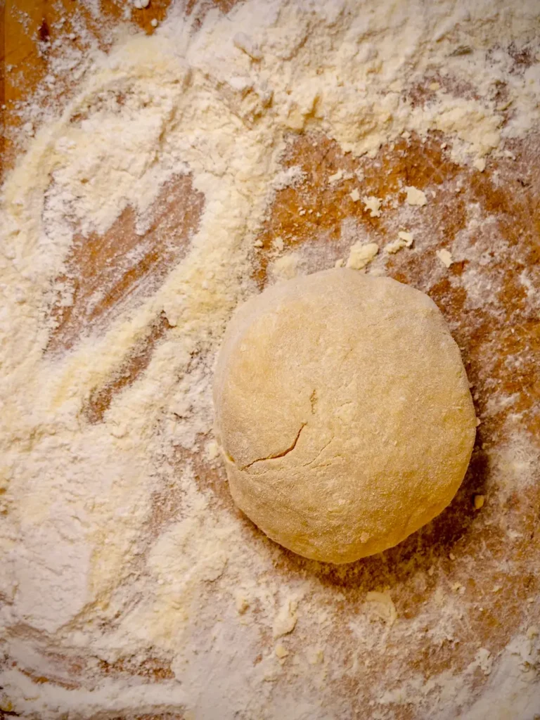 Zur Kugel geformter Pastateig ruht vor dem Ausrollen