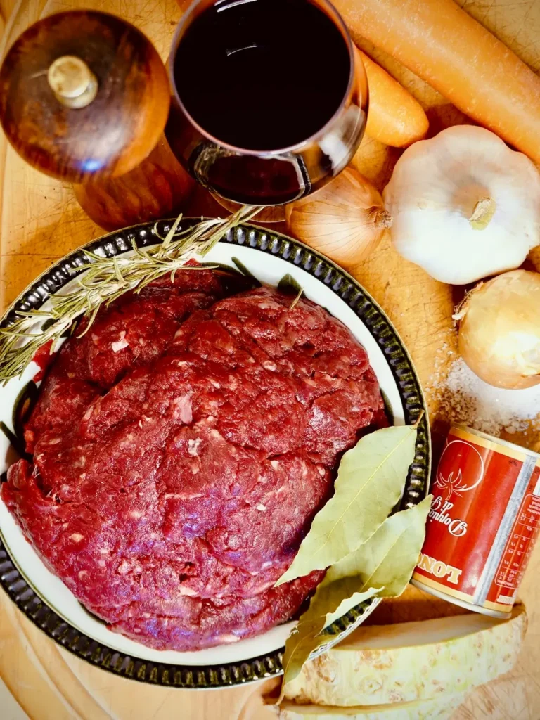 Zutaten für die Bolognese-Soße auf einem Holzbrett
