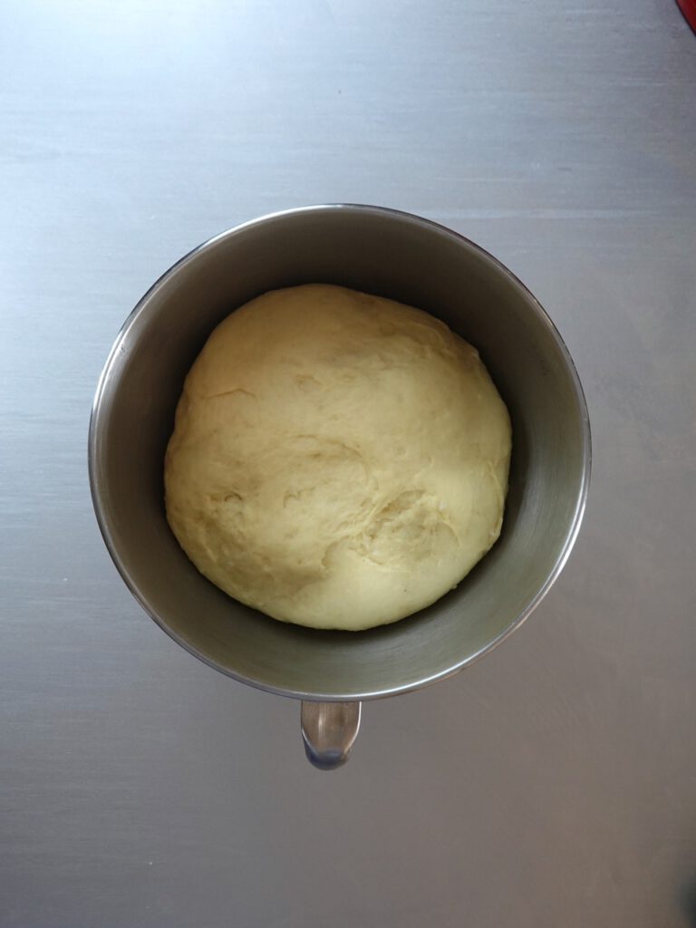 The plaited dough has been shaped into a ball in a bowl