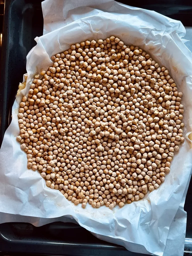 Mürbeteigboden mit Backpapier und Kichererbsen zum Blindbacken in der Kuchenform