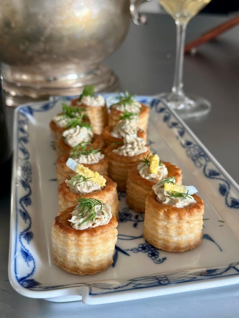 Mini Pastitli schön dekoriert neben einem Champagner.