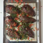 Ufen aubergine auf einem Blech gebacken, kreuzweise eingeschnitten, mit Ingwerkräutern und Paprika bestreut
