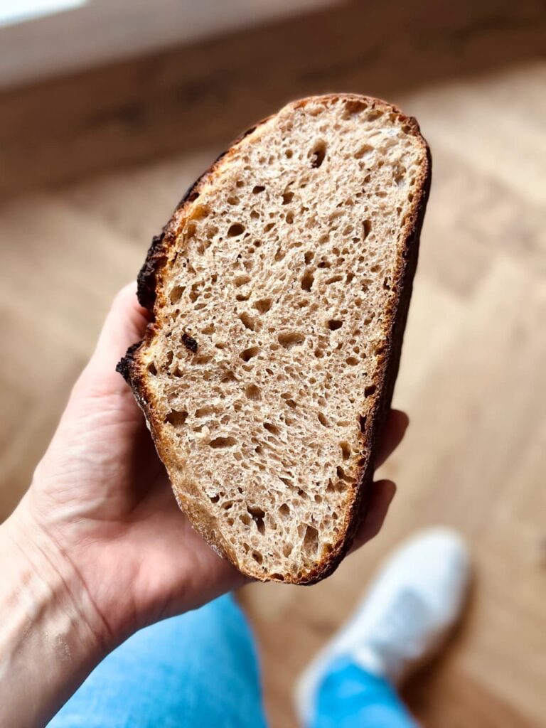 Sauerteigbrot auf Holzbrett angeschnitten, knusprige Kruste