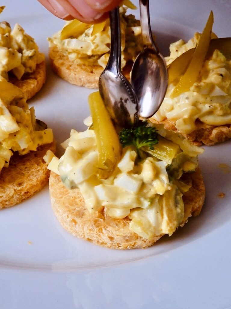 Linsenthaler mit Eiersalat dekorieren.