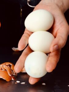 3 geschälte Eier in einer Hand