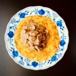 Zürcher Geschnetzeltes mit Rösti auf einem traditionellen blau-weissen Schweizer Teller