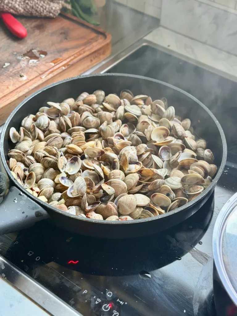 Vongole öffnen sich in der Pfanne mit Weisswein